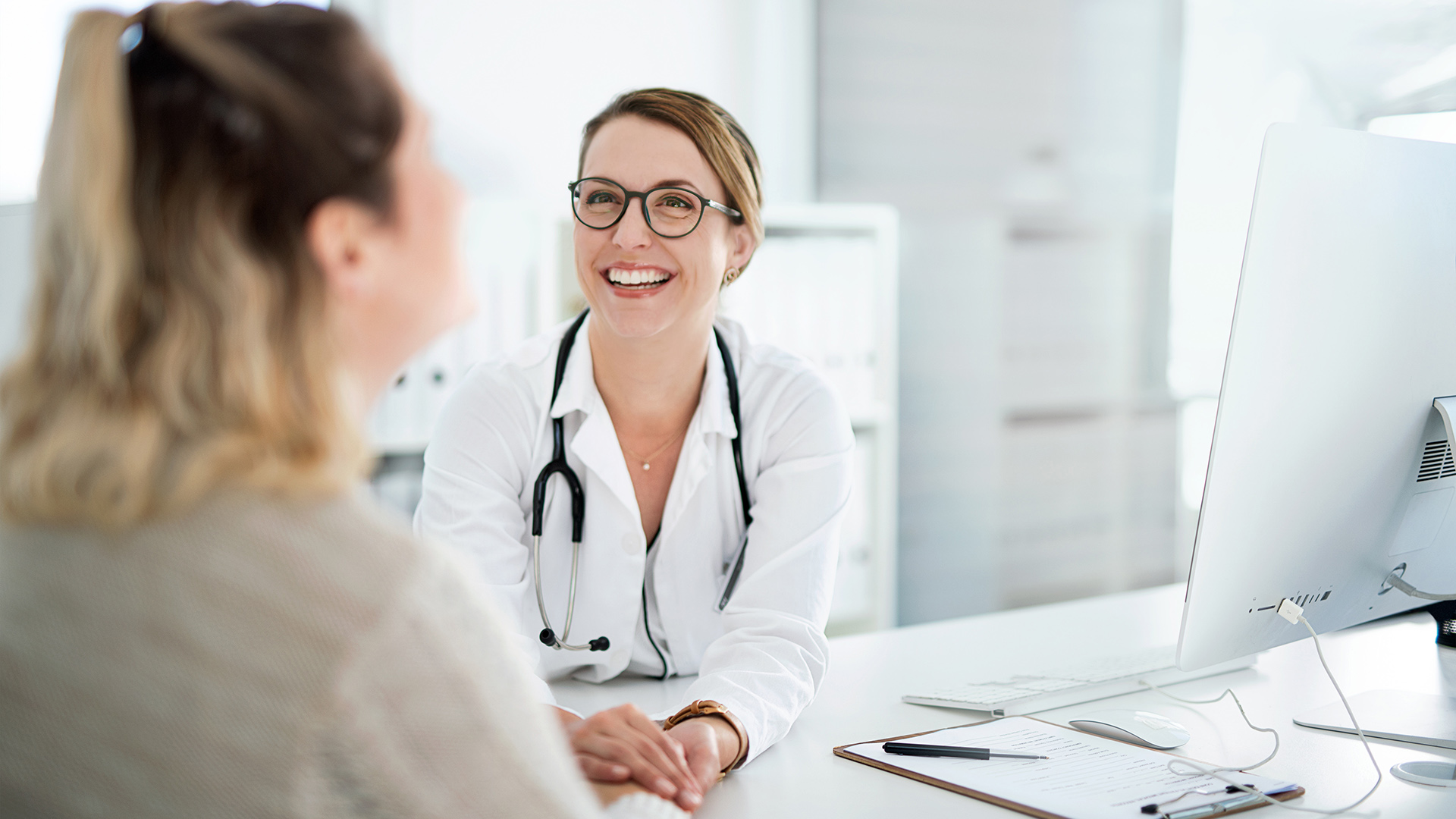 Ärztin und Patientin im Gespräch – lachend 