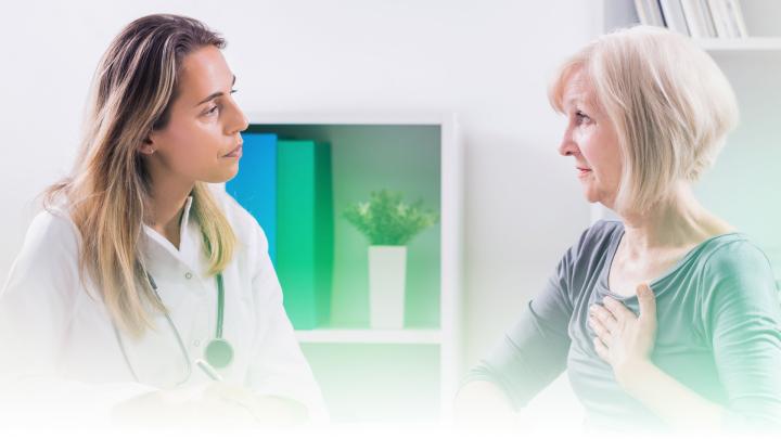 Ärztin im Gespräch mit Patientin, die sich ans Herz fasst