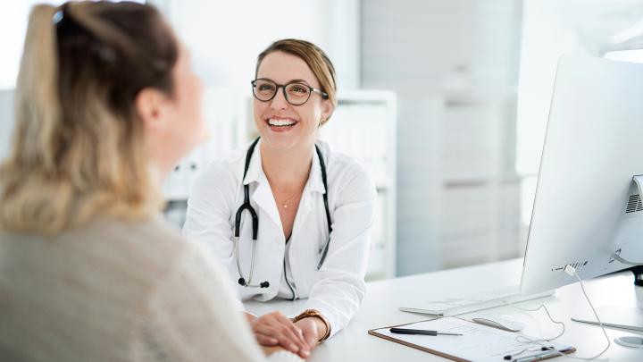 Ärztin und Patientin im Gespräch – lachend 