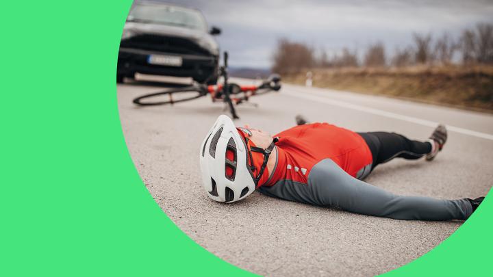 Fahrradfahrer liegt vor einem Auto auf der Straße
